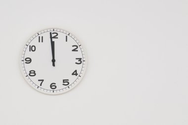 White clock with black hands showing one minute to midnight, noon clipart