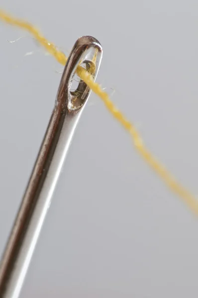 Жовта бавовняна нитка через голкове око — стокове фото