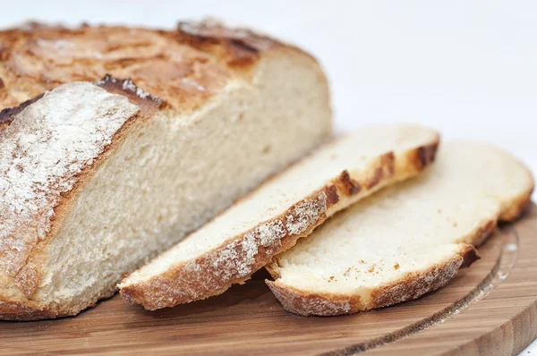 Fette di pane su un piatto di legno — Foto Stock