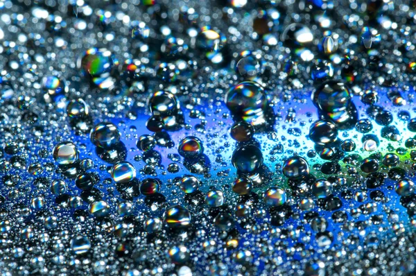 Water drops on colorful reflective surface — Stock Photo, Image