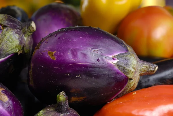 Eggplants and tomatoes on display at a market — Stock Photo, Image