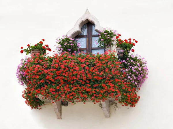 Uma varanda casa italiana com flores rosa e vermelho — Fotografia de Stock