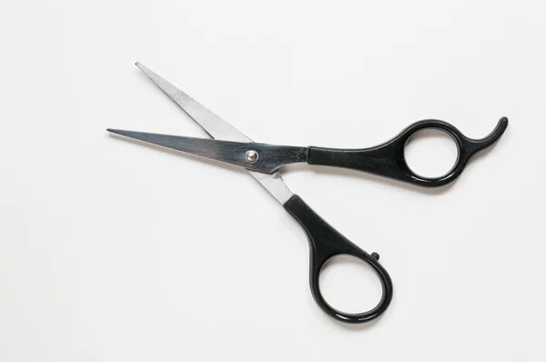 Um par de tesouras de barbeiro com punho preto — Fotografia de Stock