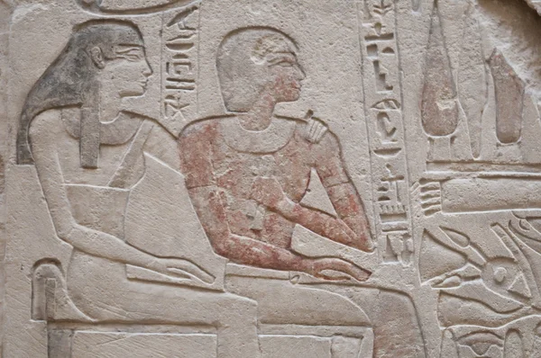 Egiptian hieroglyphs and human figures engraved on stone — Stock Photo, Image