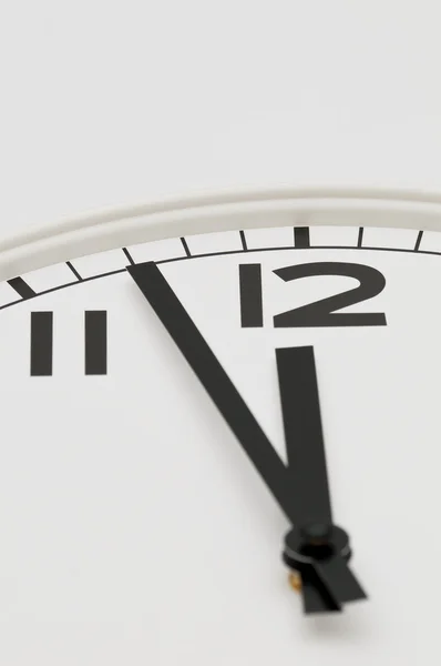 Reloj blanco con las manos negras mostrando tres minutos hasta la medianoche, mediodía —  Fotos de Stock