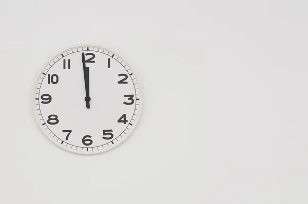 Vit klocka med svarta händer visar en minut till midnatt, noon — Stockfoto