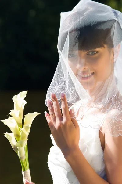 Улыбающаяся невеста с букетом — стоковое фото