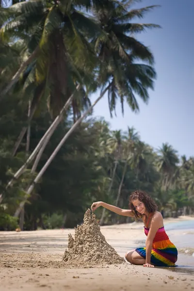 Uma mulher a construir um castelo de areia — Fotografia de Stock