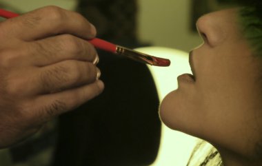 Woman getting her lips made up clipart