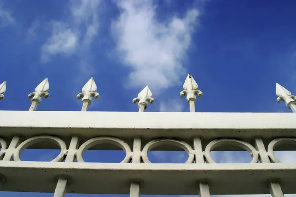 Zdjęcie detal białego metalu bramy z błękitnego nieba — Zdjęcie stockowe