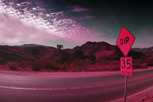Photo of desert in pink light with speed limit street sign — Stock Photo, Image