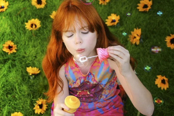 Red headed girl blowing bubbles — Stock Photo, Image