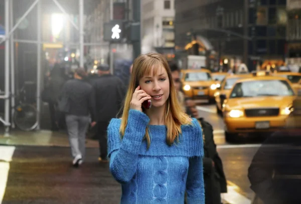 Jonge vrouw lopen met mobiele telefoon — Stockfoto