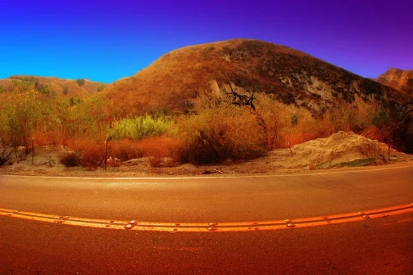 Red hill with curved road — Stock Photo, Image