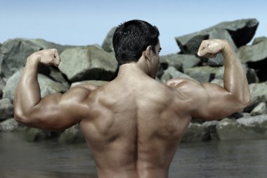 Body builder by the rocks clipart
