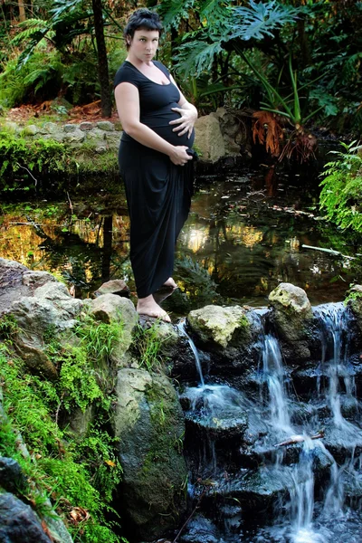 Donna incinta in un ambiente lussureggiante — Foto Stock