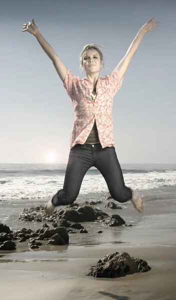 Mujer joven saltando en la playa — Foto de Stock