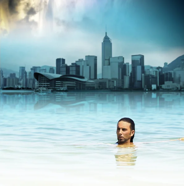 Man flyter i vatten mot bakgrund av futuristiska staden och dramatisk himmel — Stockfoto