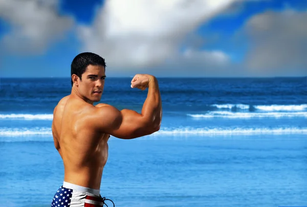 Bodybuilder op het strand — Stockfoto