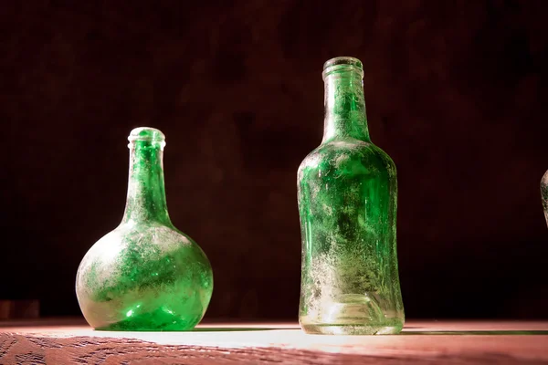 Пыльные бутылки на столе — стоковое фото