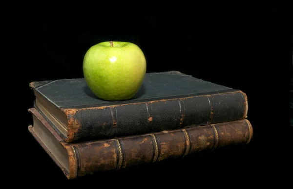 Livros velhos e uma maçã — Fotografia de Stock