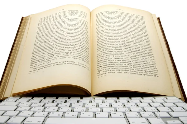 Старая книга и клавиатура — стоковое фото