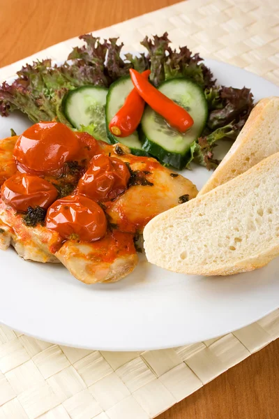 Chicken with tomatoes and bun — Stock Photo, Image