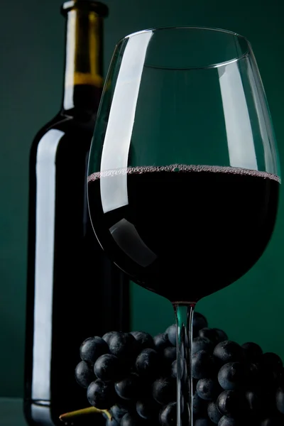 Um copo cheio de vinho e garrafa — Fotografia de Stock