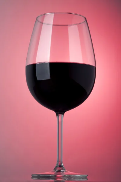 Glas rode wijn op een roze achtergrond — Stockfoto