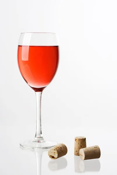 Red wine in glass and corks — Stock Photo, Image