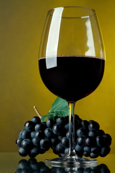 Een glas rode wijn en druiven — Stockfoto