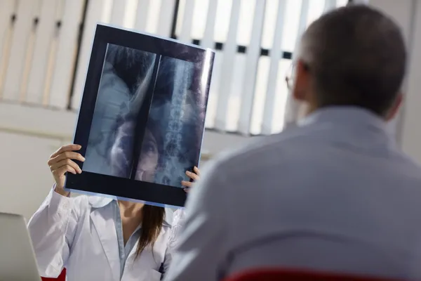 Medico donna che lavora in ospedale con paziente e radiografie — Foto Stock