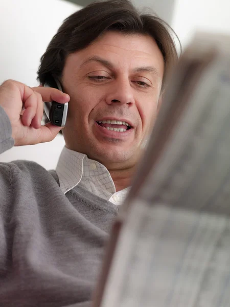 Volwassen man leest beurs aanbiedingen thuis — Stockfoto