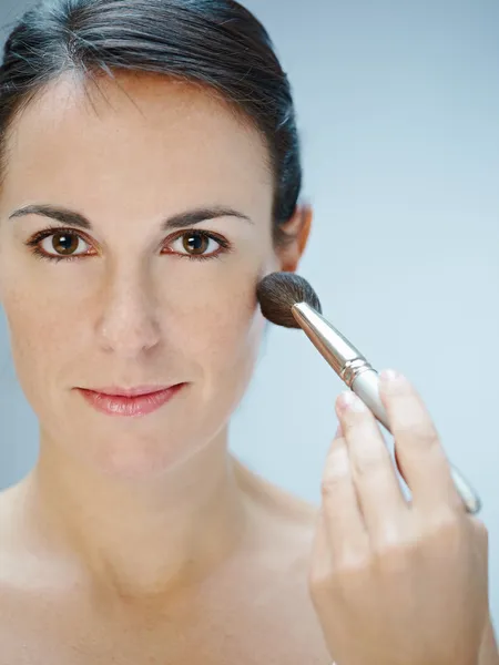 Mujer aplicando maquillaje con pincel —  Fotos de Stock