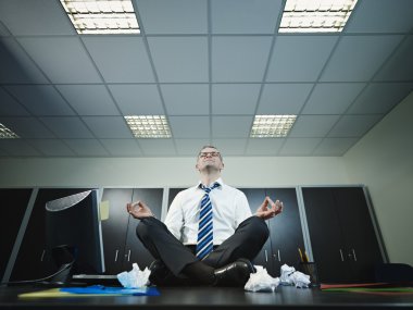 İş adamı ofiste yoga yapıyor.