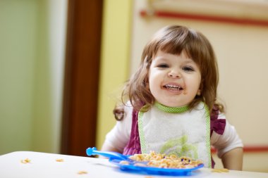 Little girl having lunch at kindergarten clipart