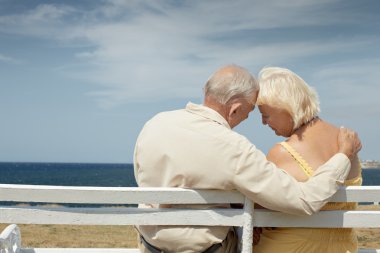 yaşlı adam ve kadın denizde bankta