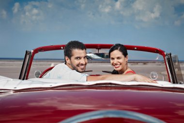 Man and beautiful woman hugging in cabriolet car clipart