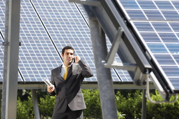 Hombre de negocios y paneles solares — Foto de Stock