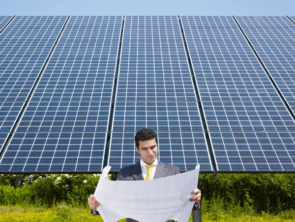 Бізнесмен стоїть біля сонячних панелей — стокове фото