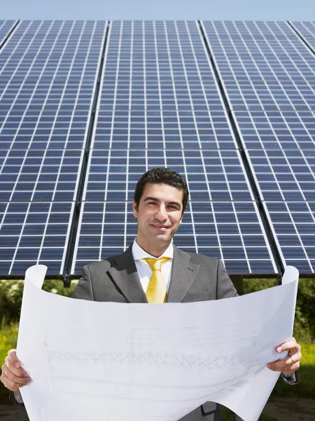 Empresário em pé perto de painéis solares — Fotografia de Stock