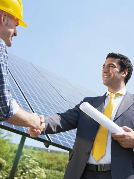 Businessman and electrician shaking hands — Stock Photo, Image