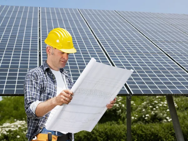 Electrician standing near solar panels — Stock Photo, Image