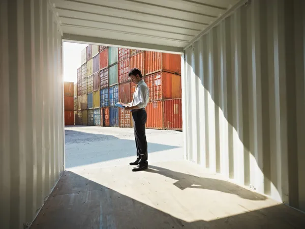 Деловой человек с грузовыми контейнерами — стоковое фото