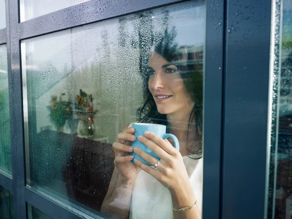 Donna che fissa la finestra — Foto Stock