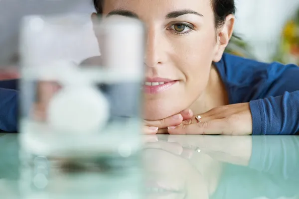 Woman looking at aspirin in glass of water — Stok fotoğraf