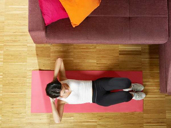 Woman doing abs exercise at home — Stok fotoğraf