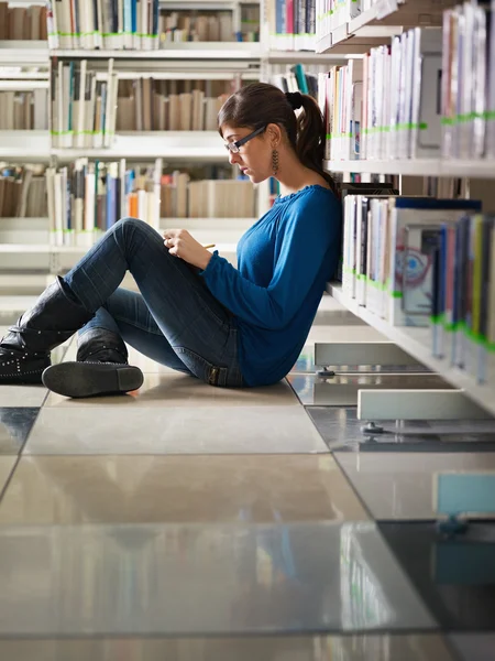 Dziewczyna studiuje w bibliotece — Zdjęcie stockowe