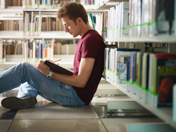 Guy studeren in bibliotheek — Stockfoto