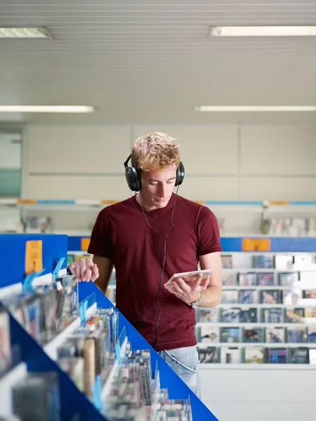 Guy ouvindo música na loja de cd — Fotografia de Stock